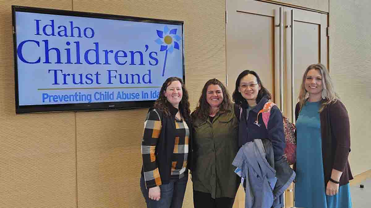 Four women standing next to an Idaho Children's Trust Fund sign.