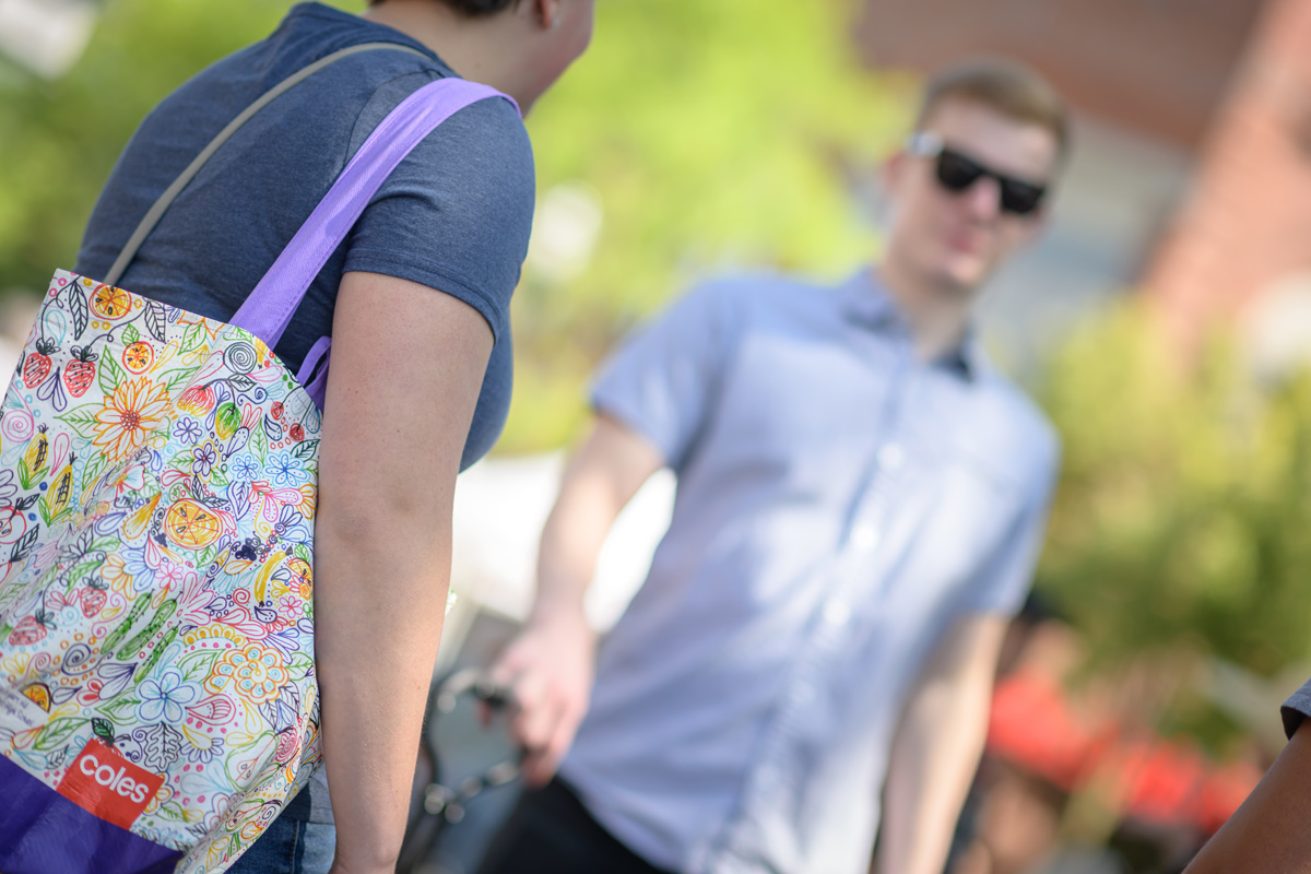 A student carries a reusable bag on campus