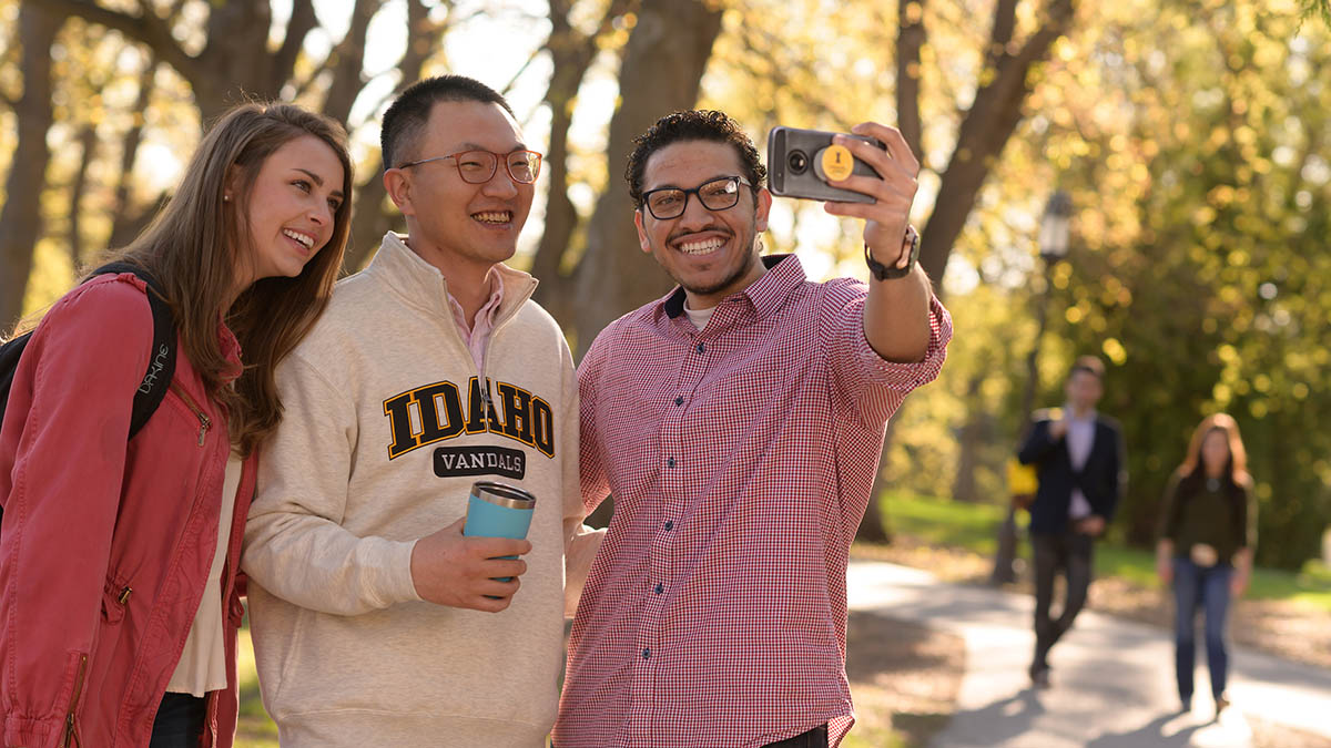 Three international students take a selfie on Hello Walk