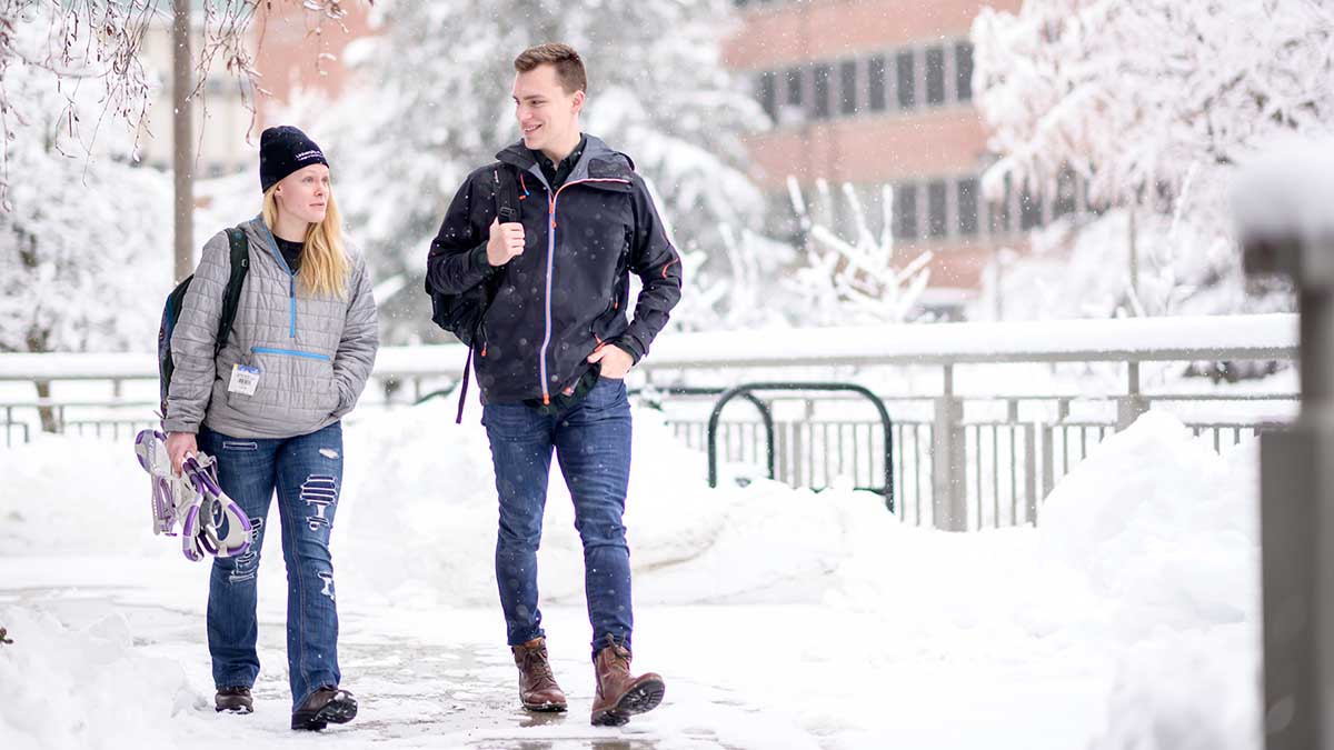 Students walking on campus while it is snowing