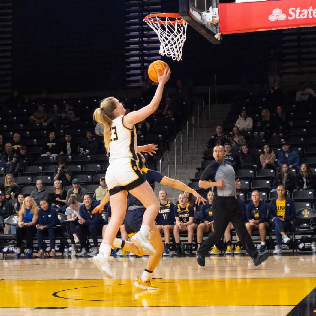 A U of I women's basketball team member jumping to make a basket during a home game in the ICCU arena