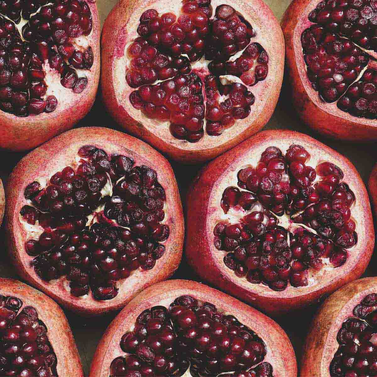 Ripe pomegranates with tops cut open.