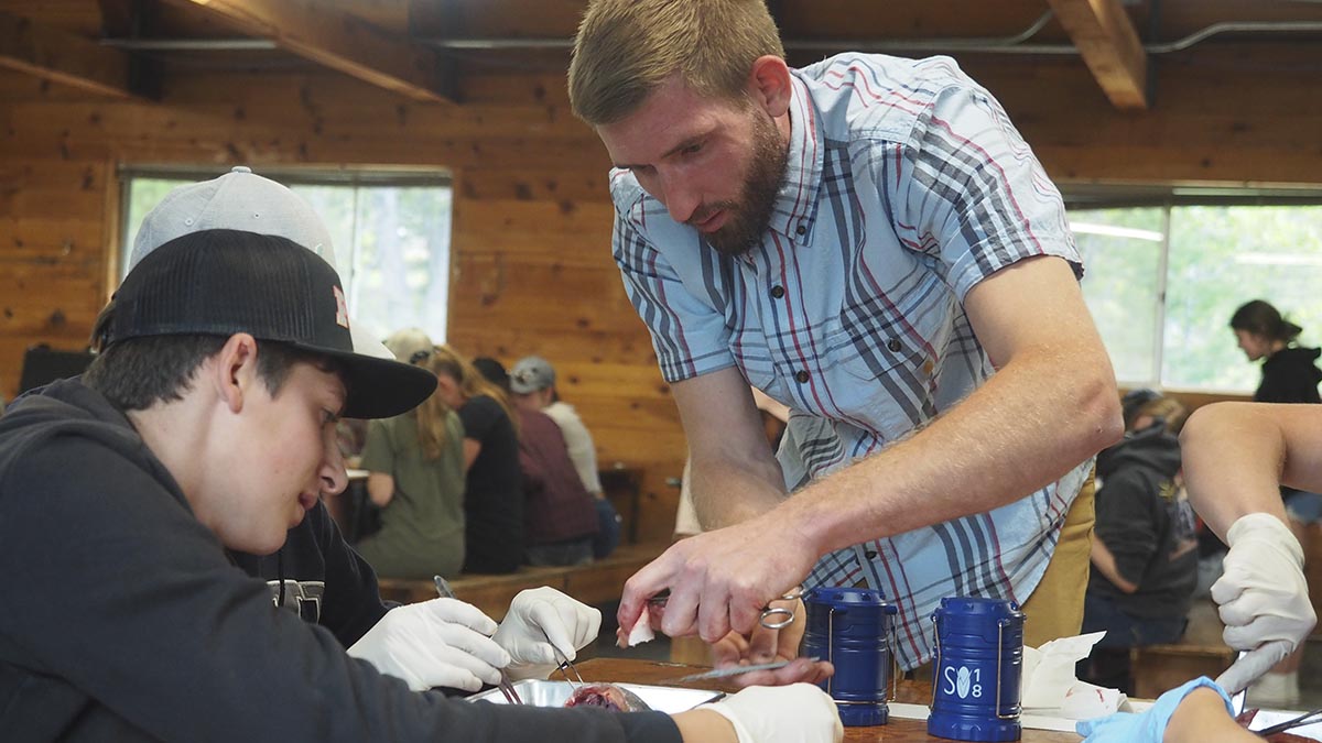 Jake helping campers with a fish dissection.