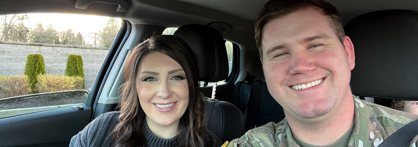 Smiling couple in front seat of car.