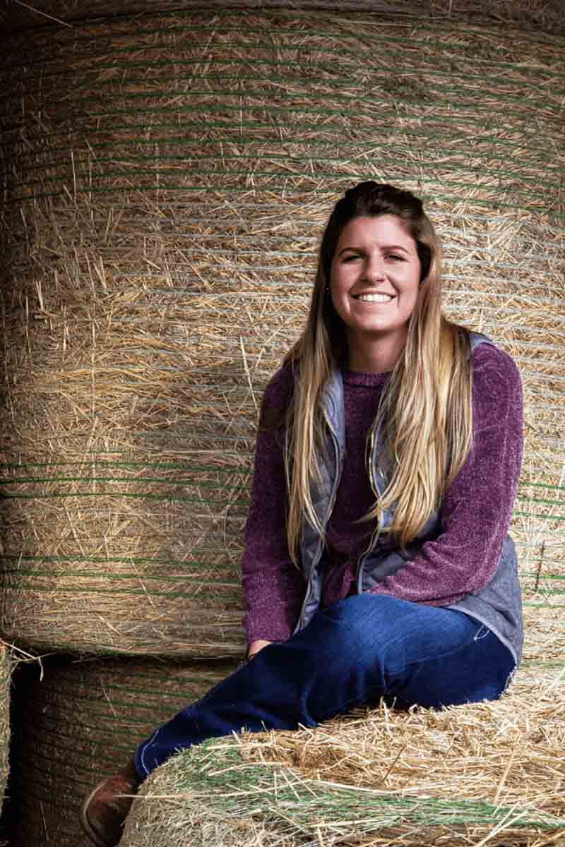 Chanelle Brusseau sits on hay bale by the U of I Beef Center.