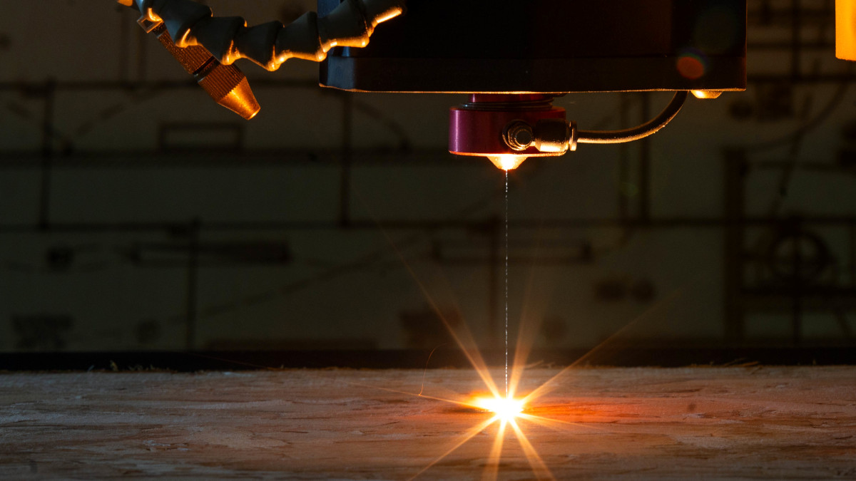 machine uses laserbeam to etch into wood panel