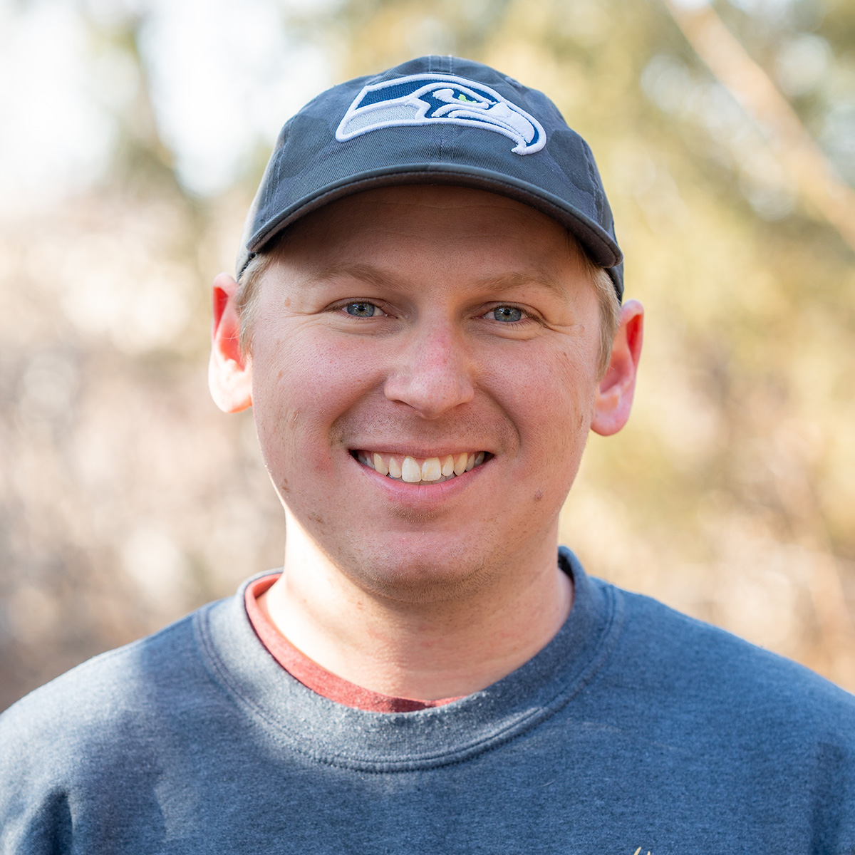 Smiling man with ballcap.