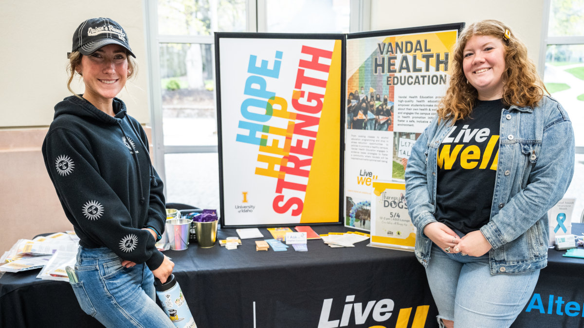 Two U of I students standing in front of a table display.