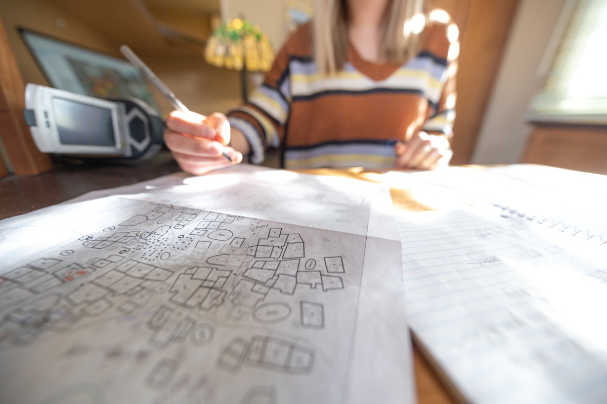 A map of a Nigerian village sits in front of Madison Thurston.