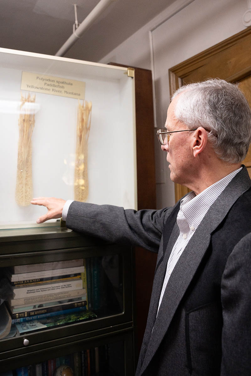 Man points to bones in display case