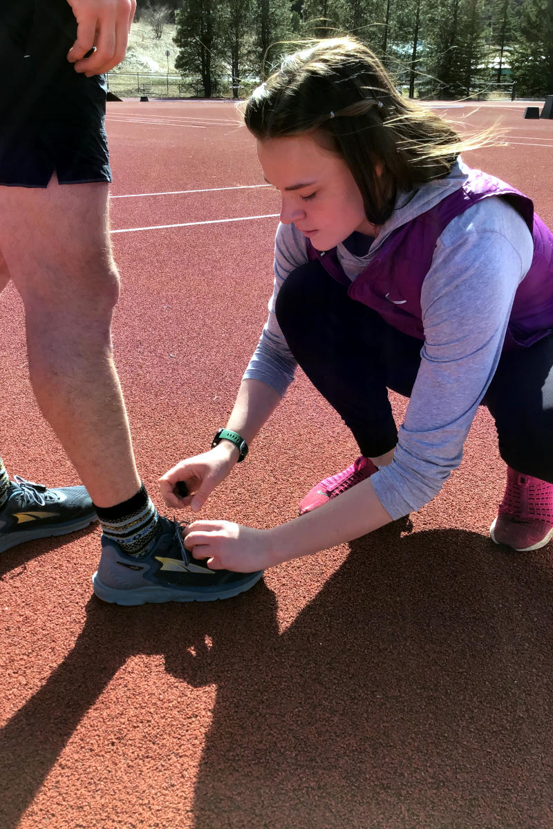 person attaching a monitor to shoes.