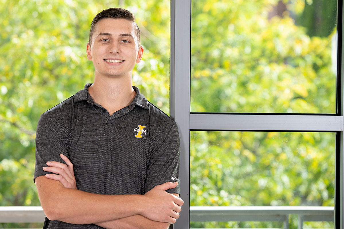 Smiling student with arms crossed.
