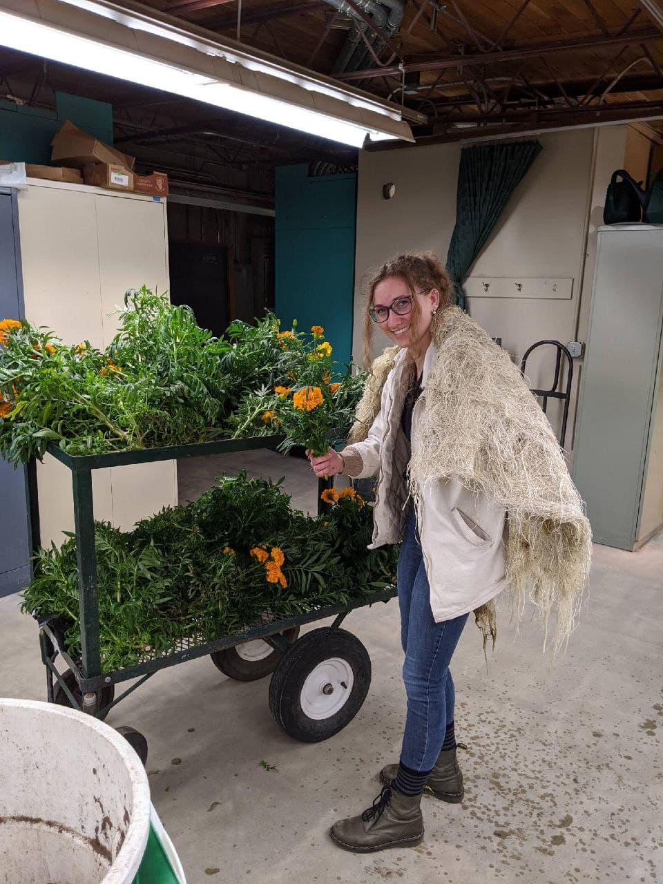 Madi Hawkins shows off flowers grown on campus in hydroponic production.