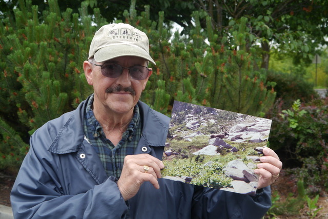 Bob Case holds an image of a caribou.