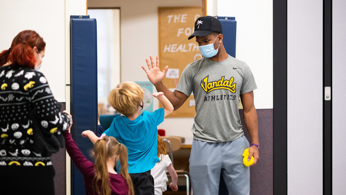 Vandal defensive back Wyryor Noil plays a game with a young girl in a Lena