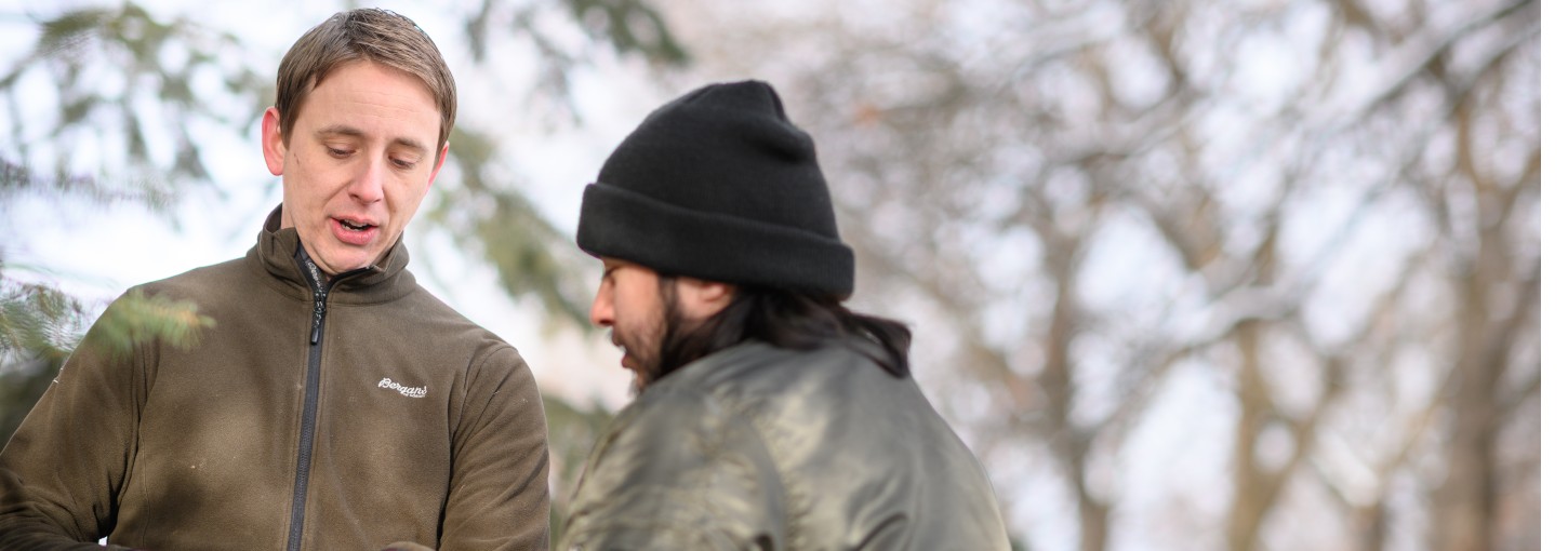 Kenny Wallen talks with someone in a forest.