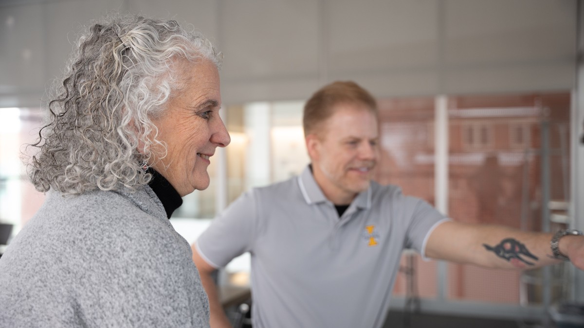 Researchers Helen Brown and Erich Seamon smile as they look at a screen.