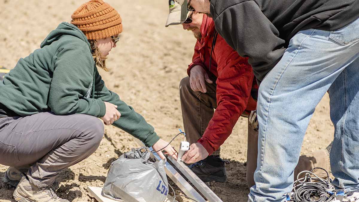 Researchers Linda Schott, Kevin Kruger and Erin Brooks discuss the placement for installing crop sensors.