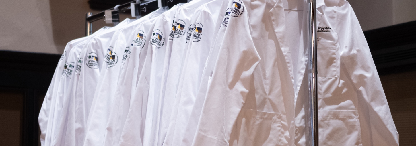 White coats hang from a bar