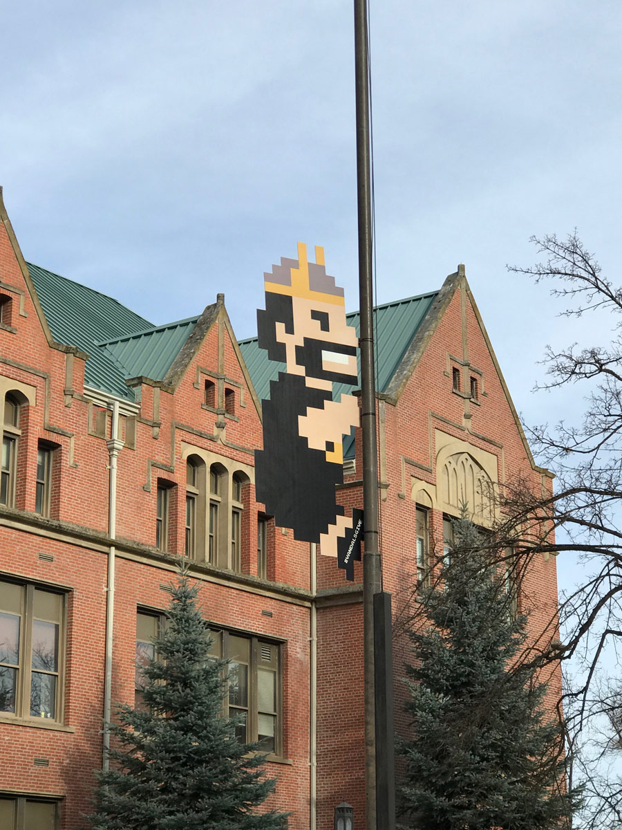 8-bit Joe Vandal climbs the flagpole in front of the Administrative Building.