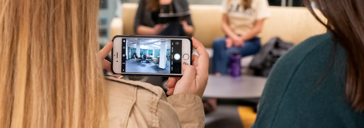A student takes a photo on her iPhone in the renovated Albertson Building basement.