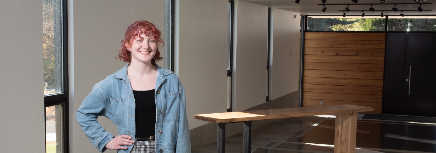 Sonya Fernandes stands beside the table she designed for the University House table competition.