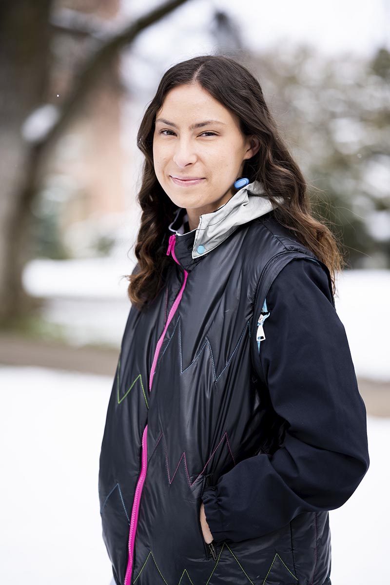 Portrait of a woman in a black jacket outside.
