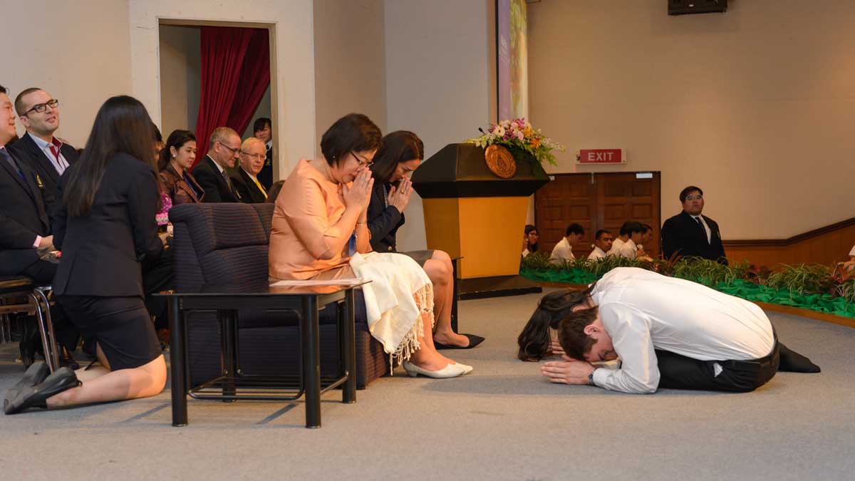 Two students bowing to teachers in Thailand.