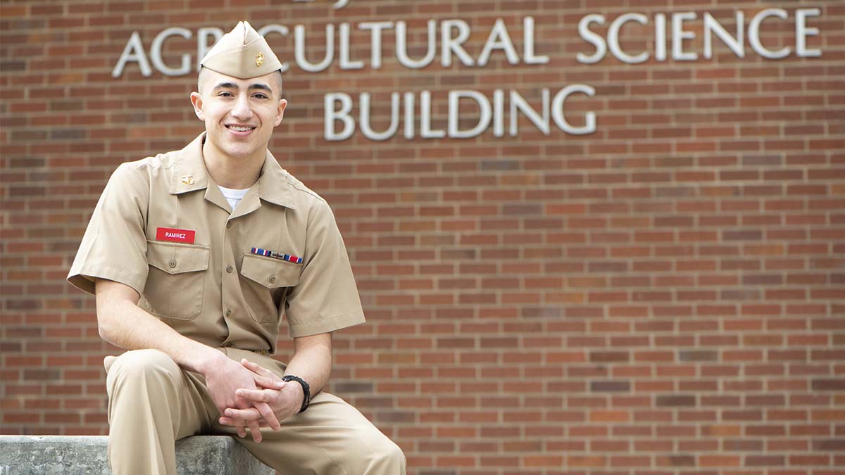 Man in Marines uniform in front of brick building.
