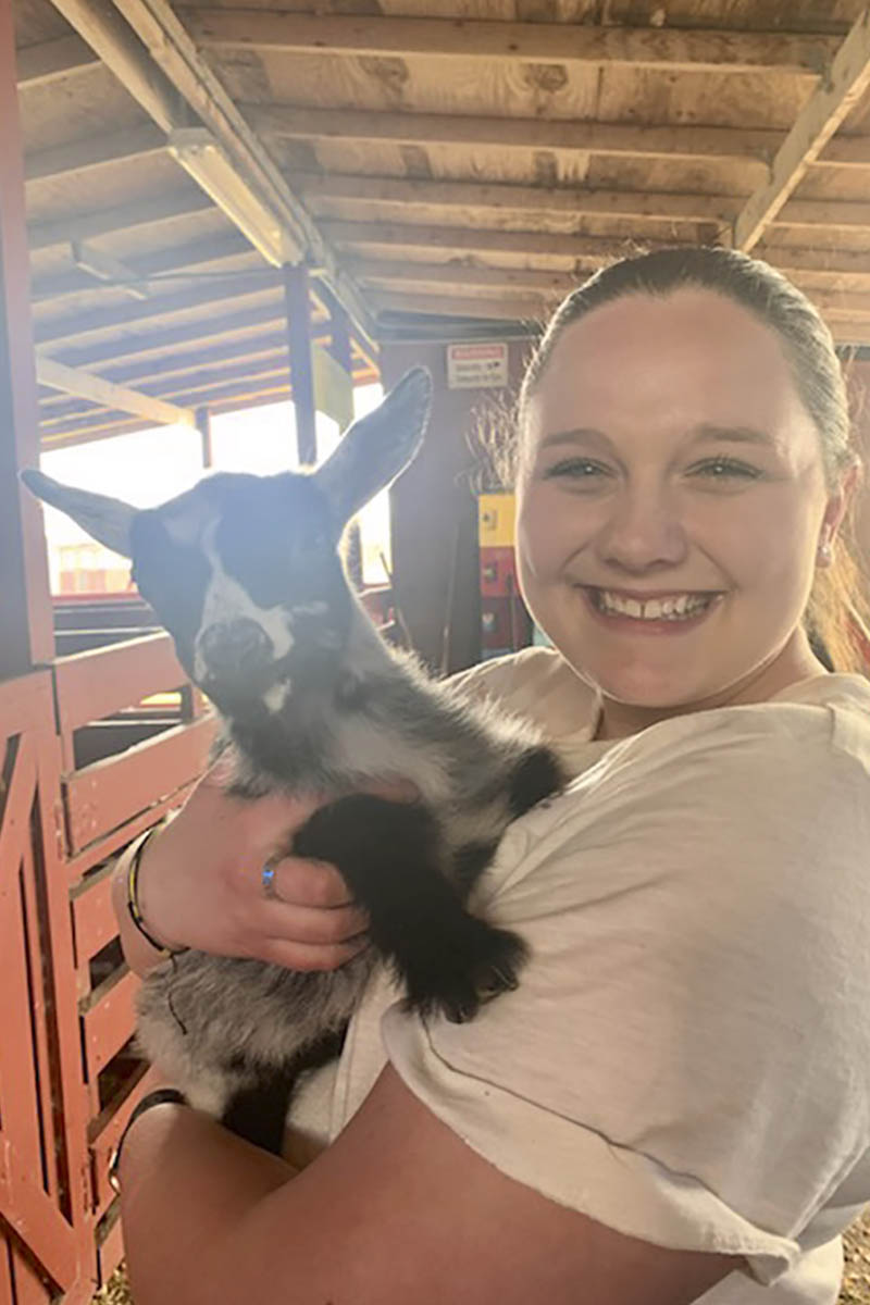 Woman holding a goat.