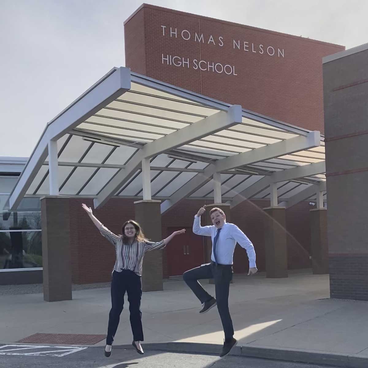 A woman and man standing in front of a school.
