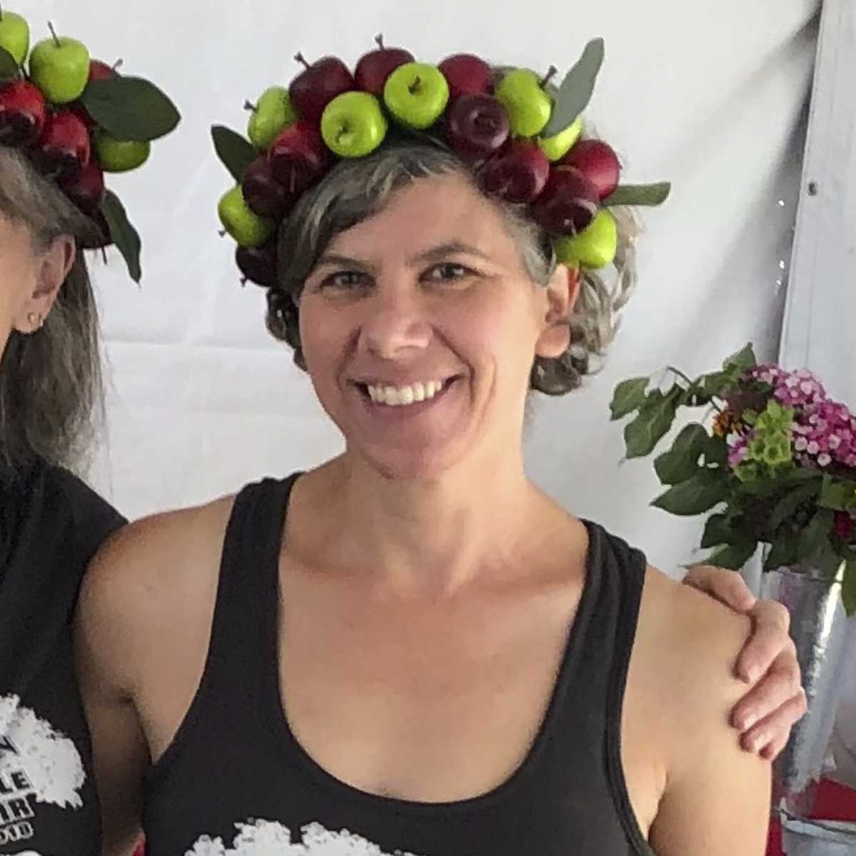 Two women wearing apple hats.