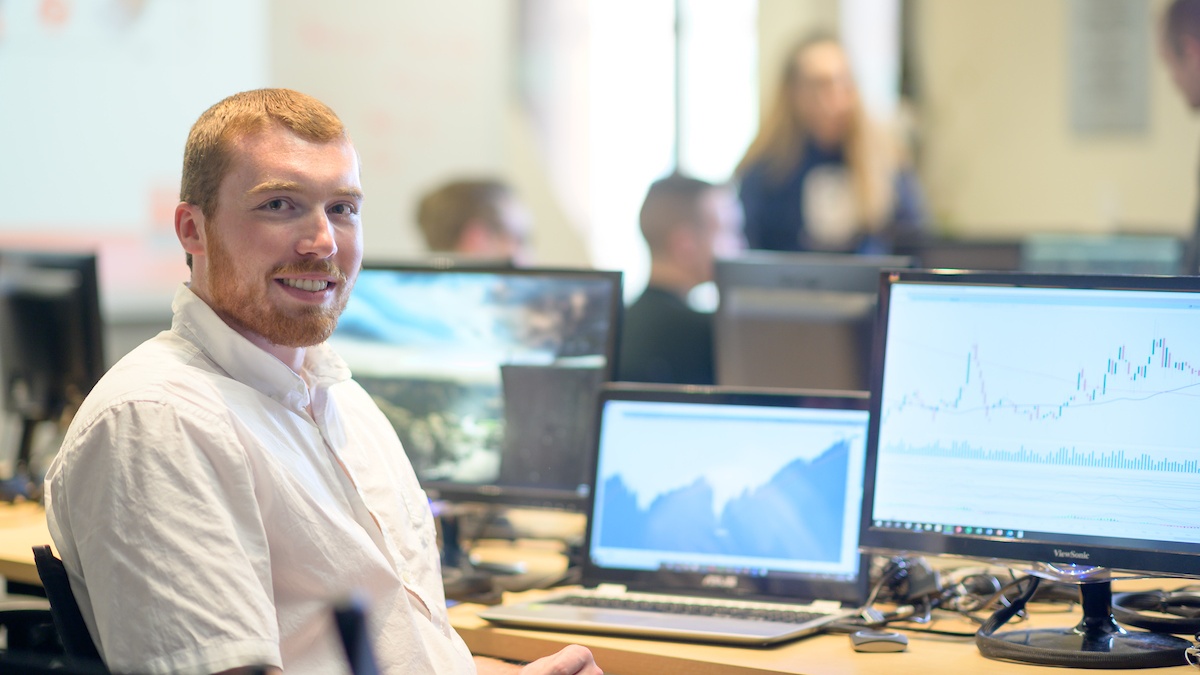 Justin Chapman smiles while working in the Barker Trading Lab
