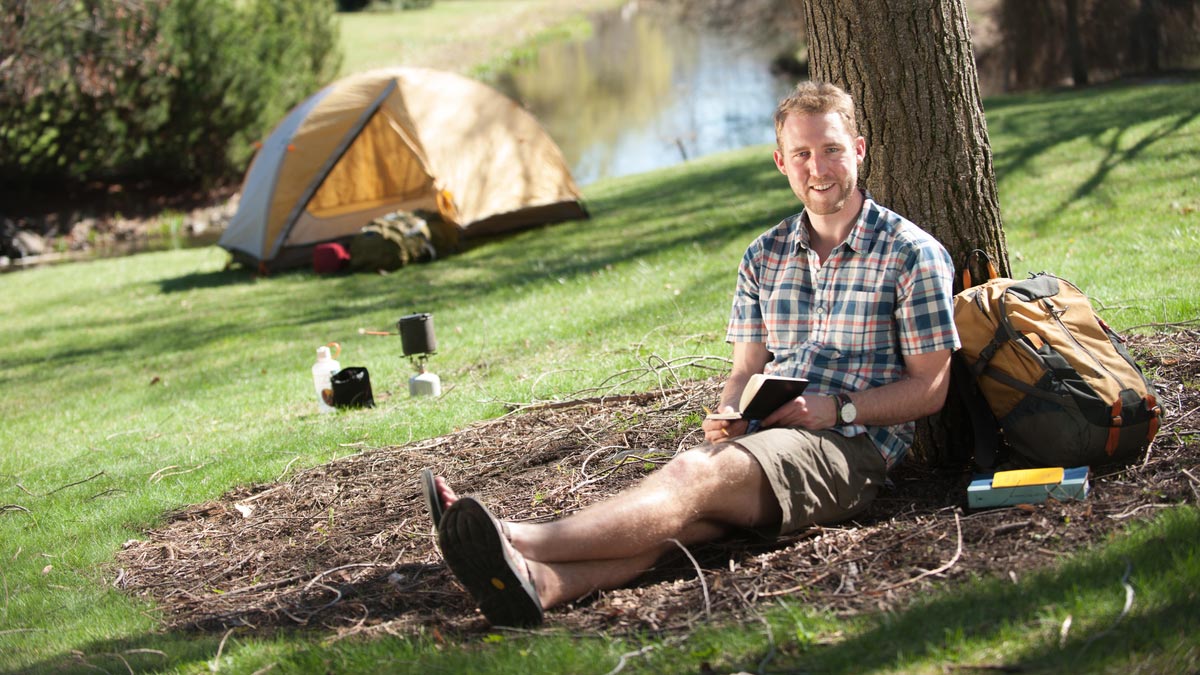 David Whitt reading at his campsite.