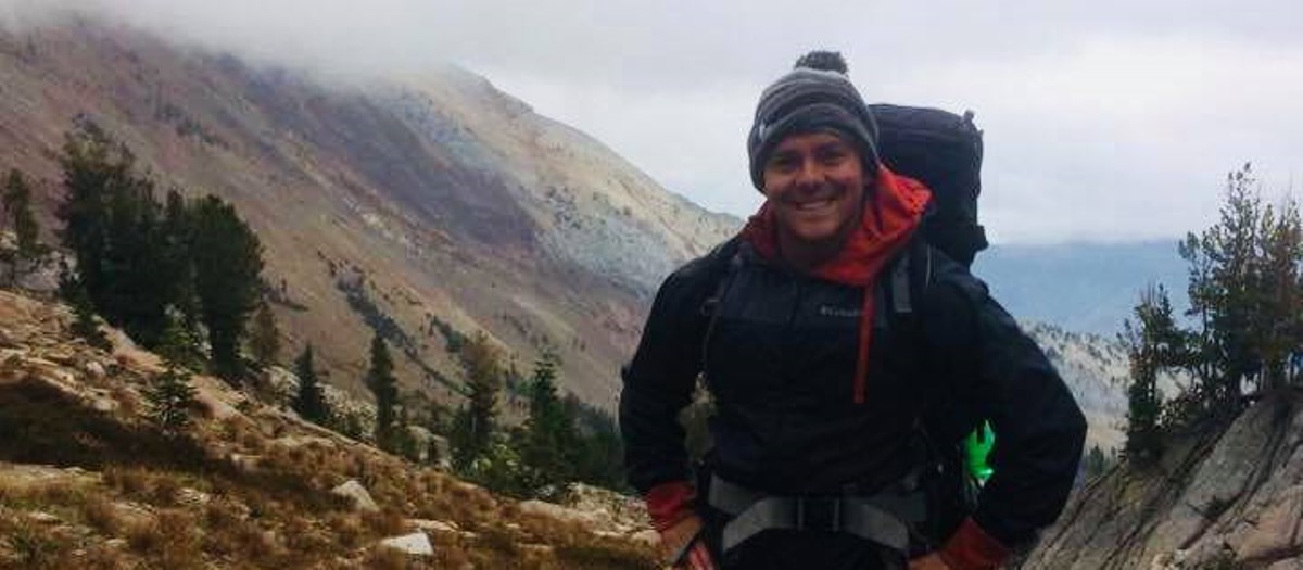 Brett Travis hiking on a mountain