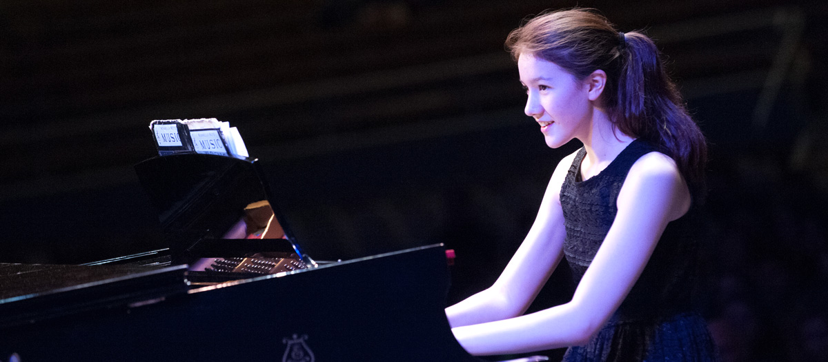 Student plays the piano onstage