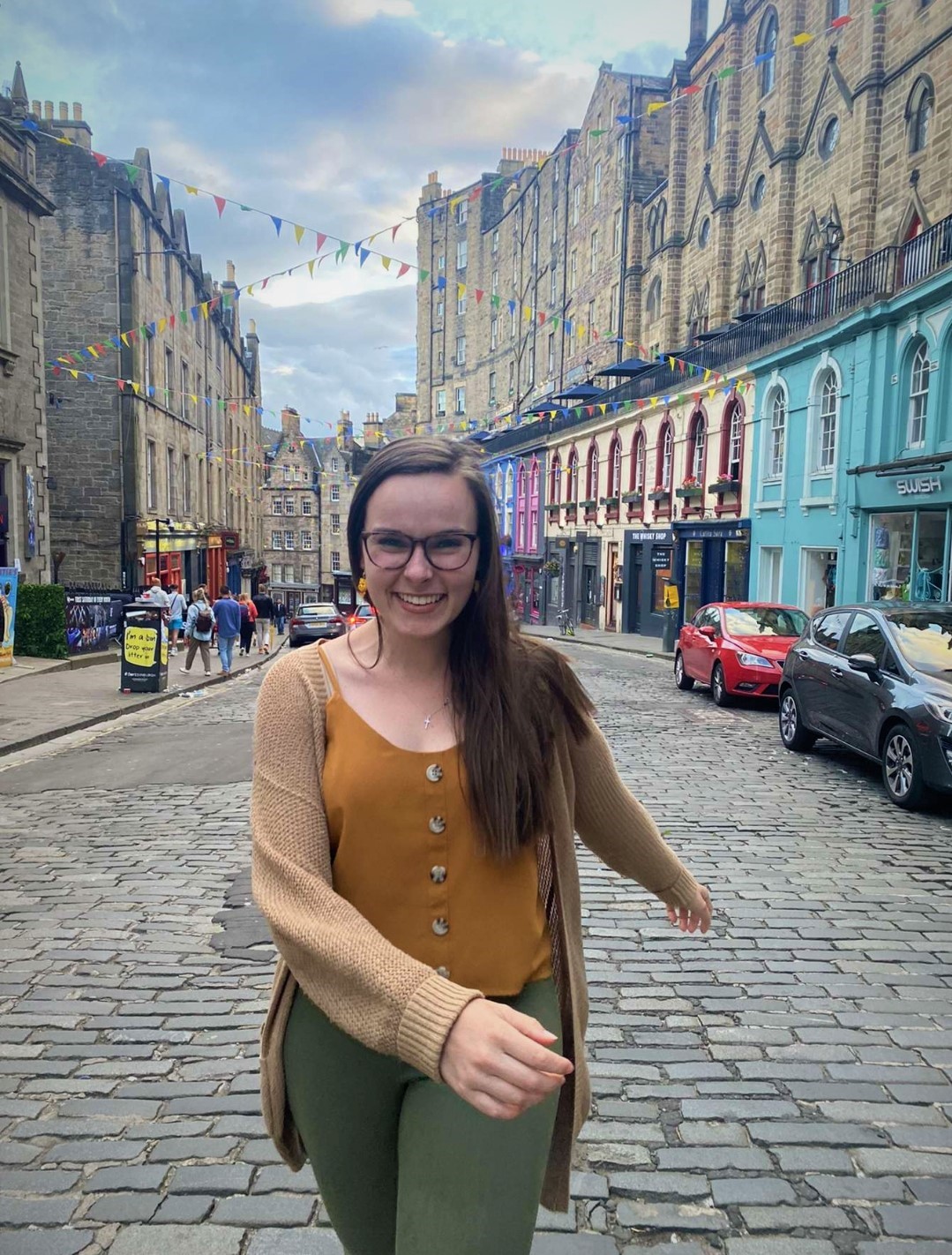 Smiling woman walking a street in Edinburgh, Scotland.
