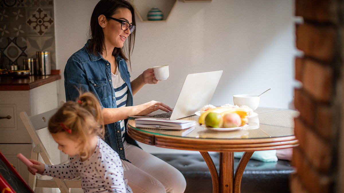 Woman studying while child plays.