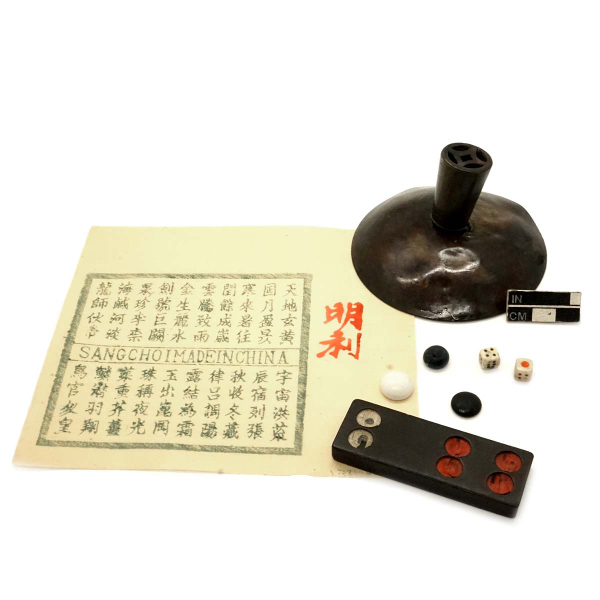 Chinese lottery ticket, “spreading out cover,” glass gaming pieces, dice, and a domino. 