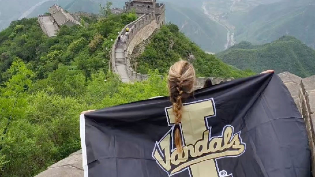Student with University of Idaho flag on Great Wall of China