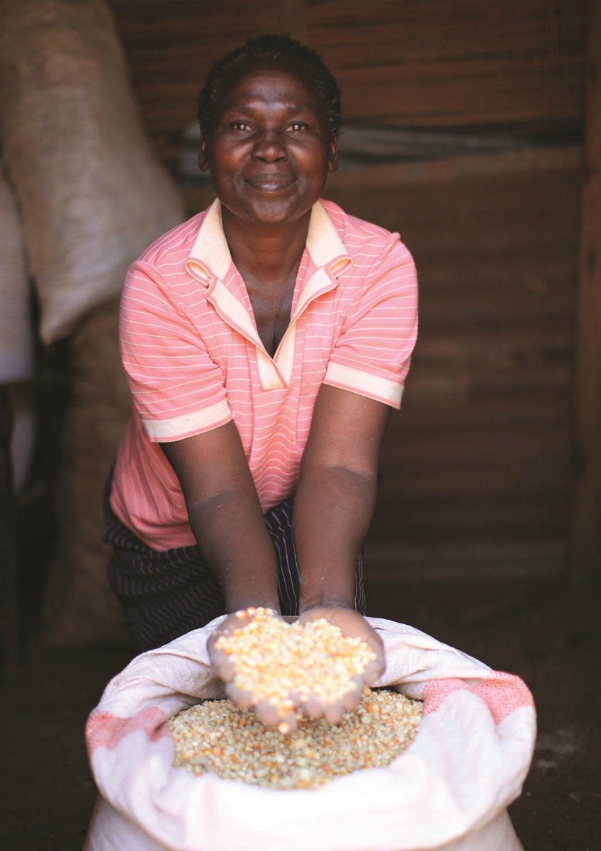 Woman holding corn as part of the Smallholder Farmer Market Access Initiative