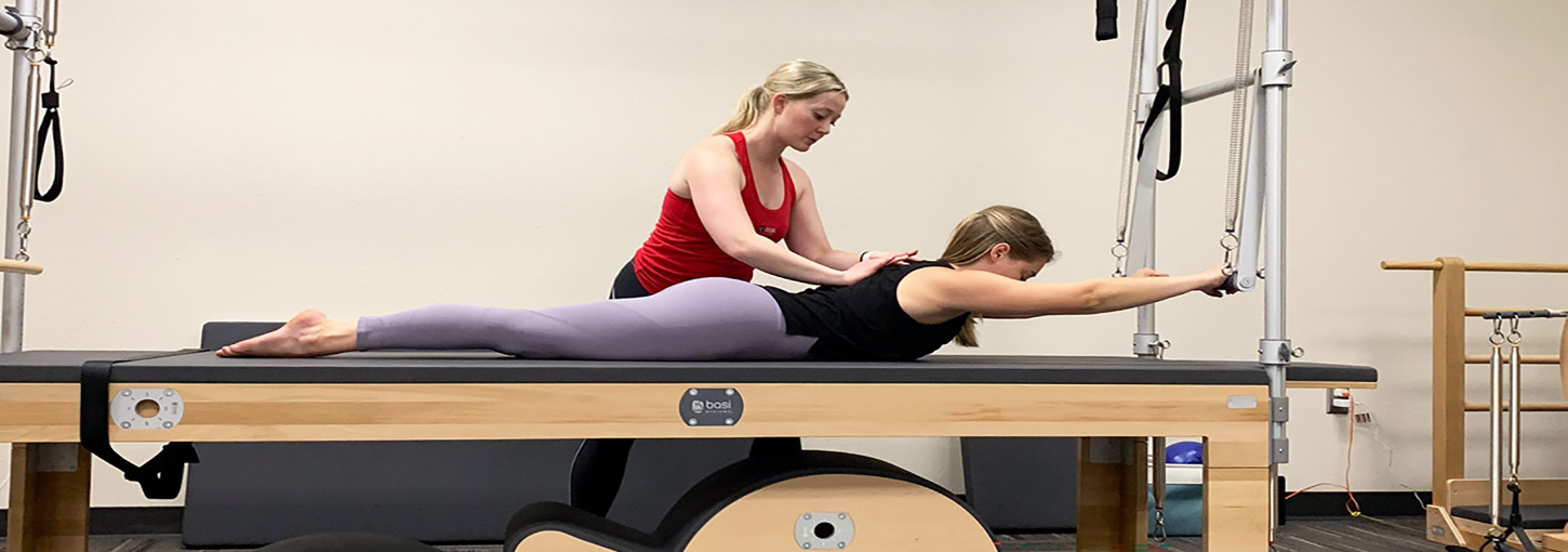Pilates instructor assist another person