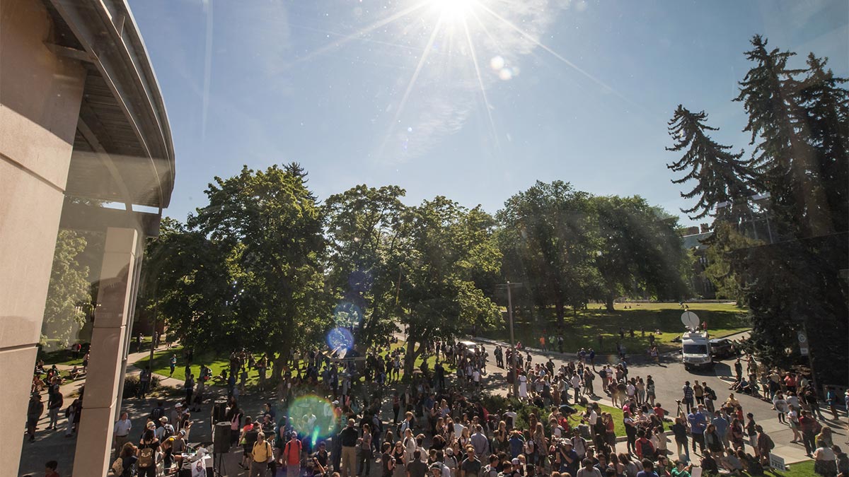 Large crowd gathered outside the commons during a solar eclipse