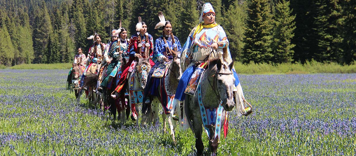 Tribe on horseback in field