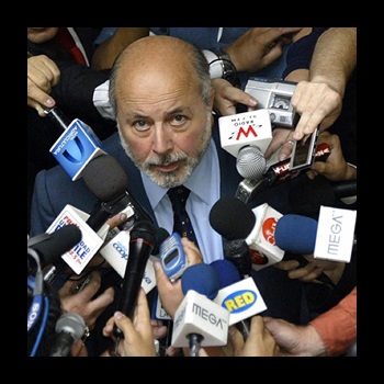 Former Judge and Justice Juan Guzmán surrounded by microphones and media members.