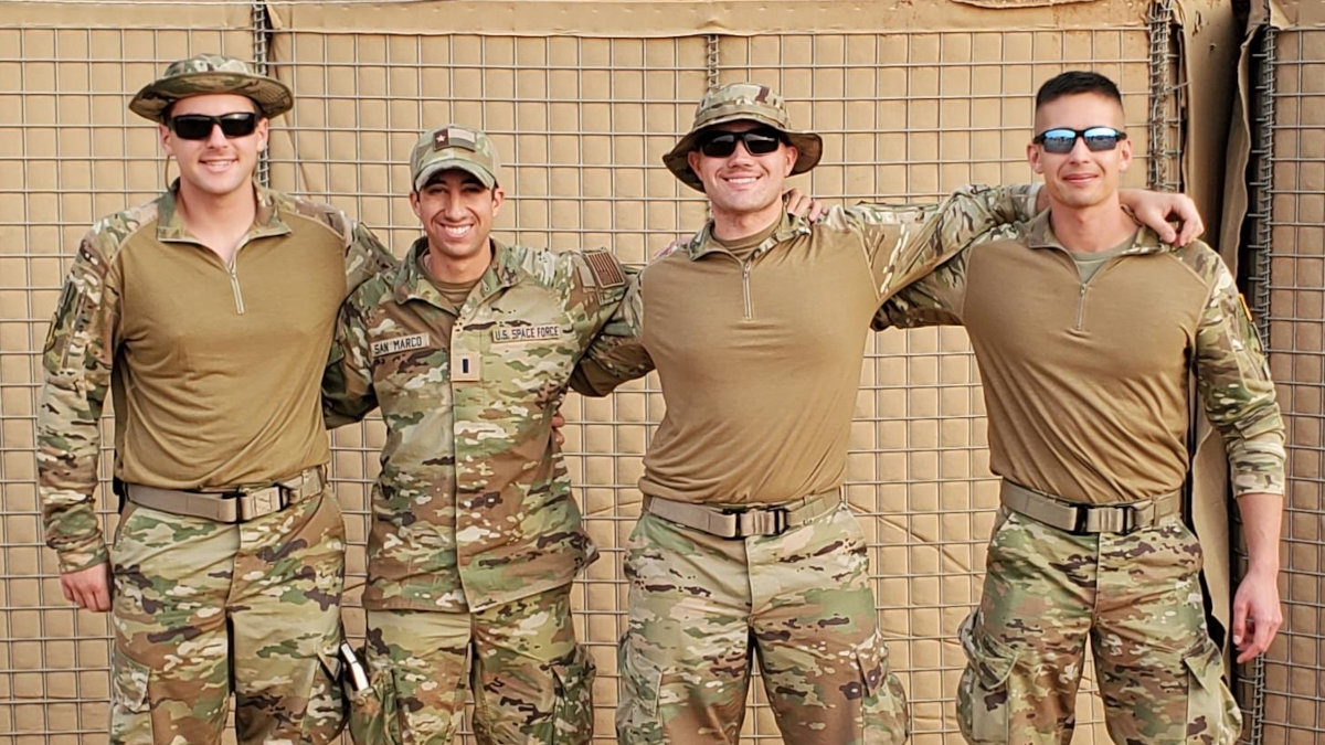 Eugene Russell stands with a group of three other team members in military gear.