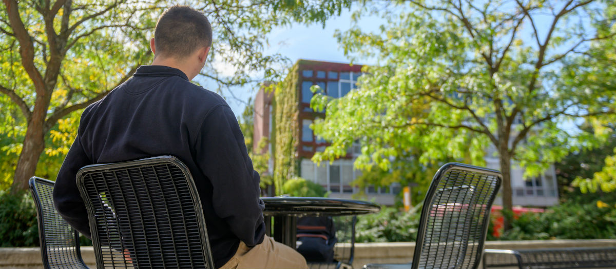 student sitting outside on U of I campus