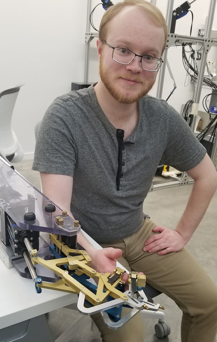 Graduate Student, Marshall Townsend, demonstrates the FINGER robot.