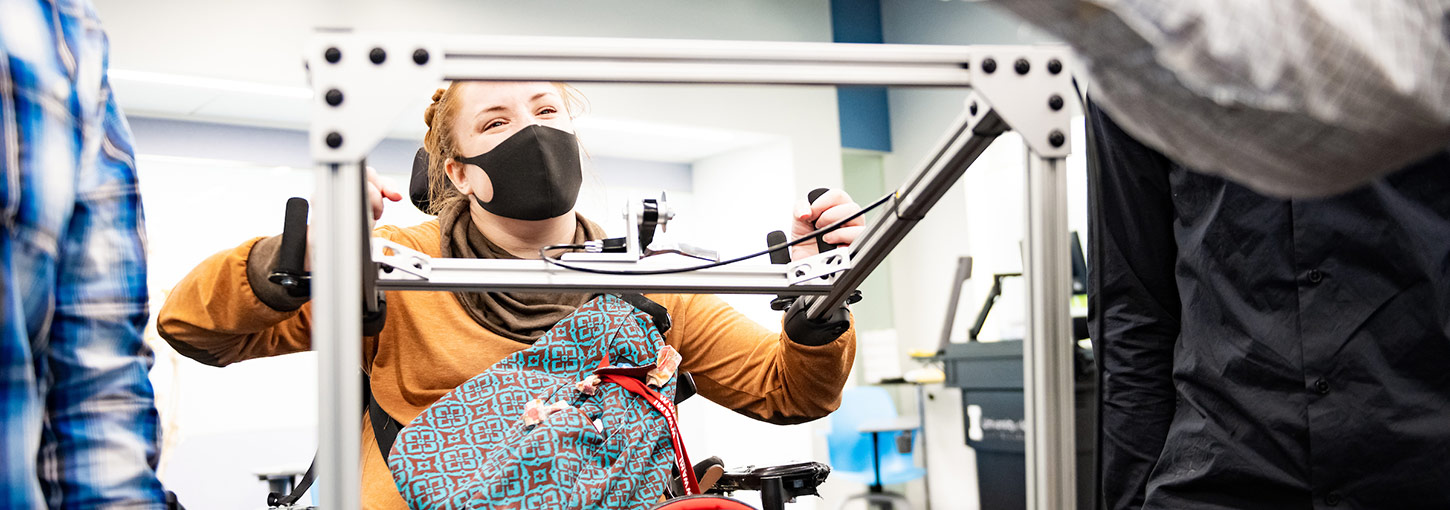 A WWAMI Medical Education Program student, who uses a wheelchair, test the assistive CPR device developed by College of Engineering students.