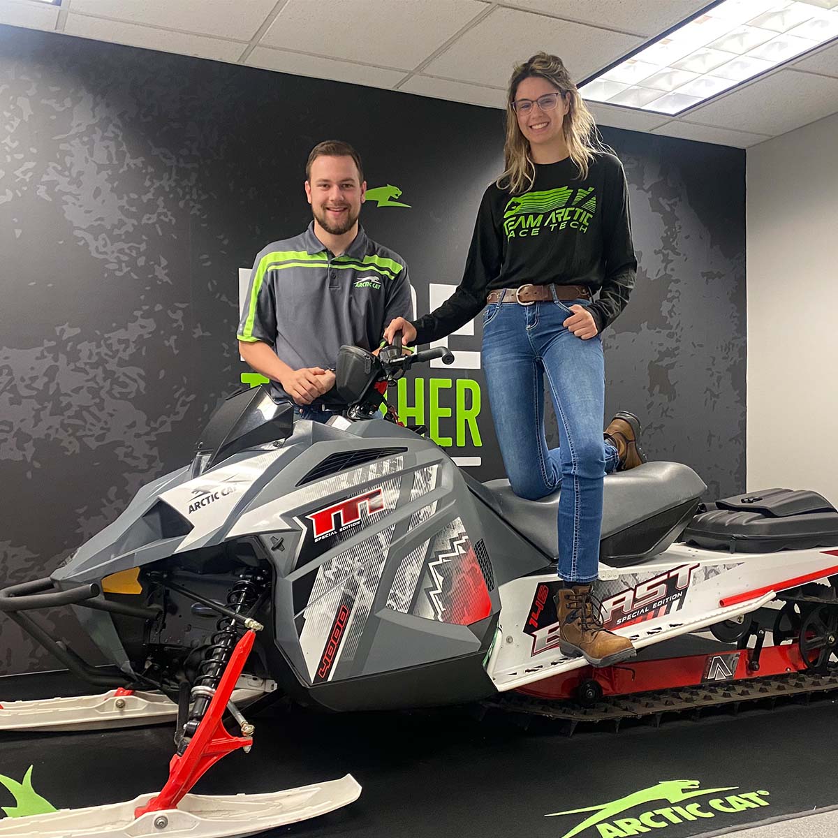 McKenzie and Thiel pose for a photograph on an Arctic Cat snow machine. 